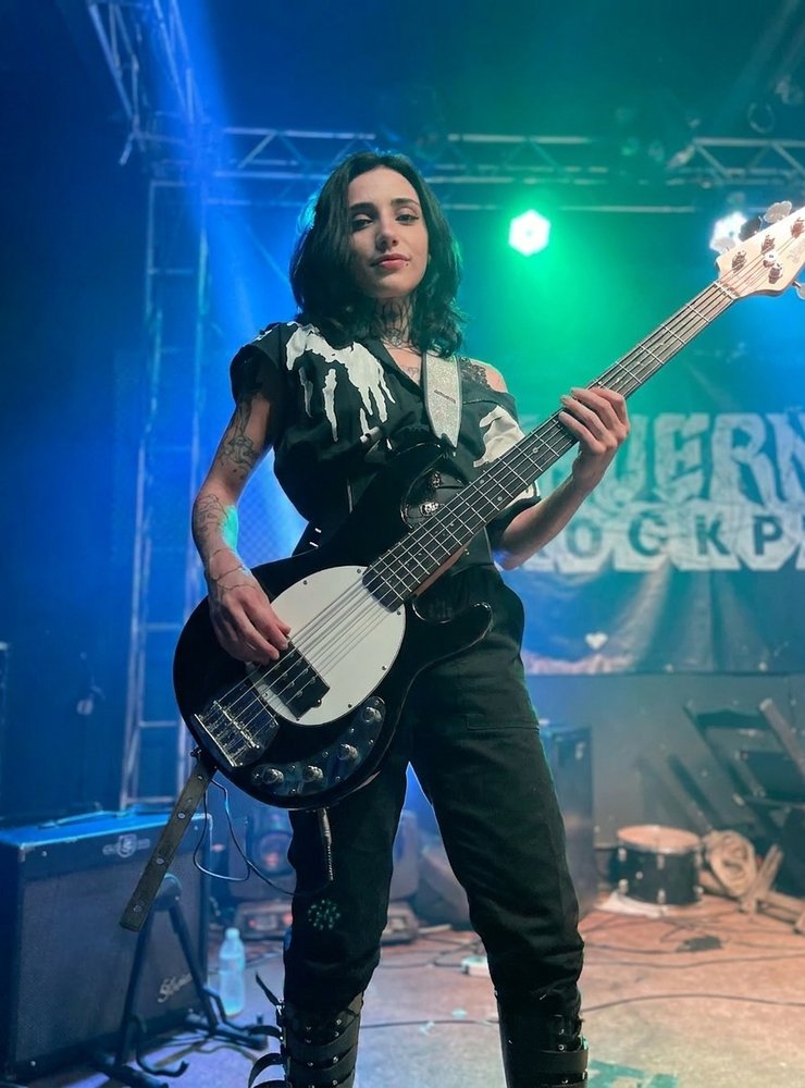 Júlia tocando baixo em show